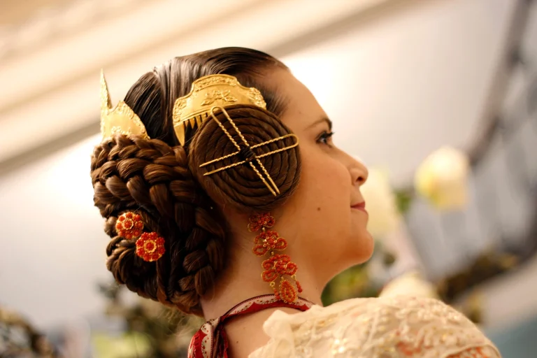 Peinado tradicional de fallera con rodetes y adorno dorado en la moda fallera 2026