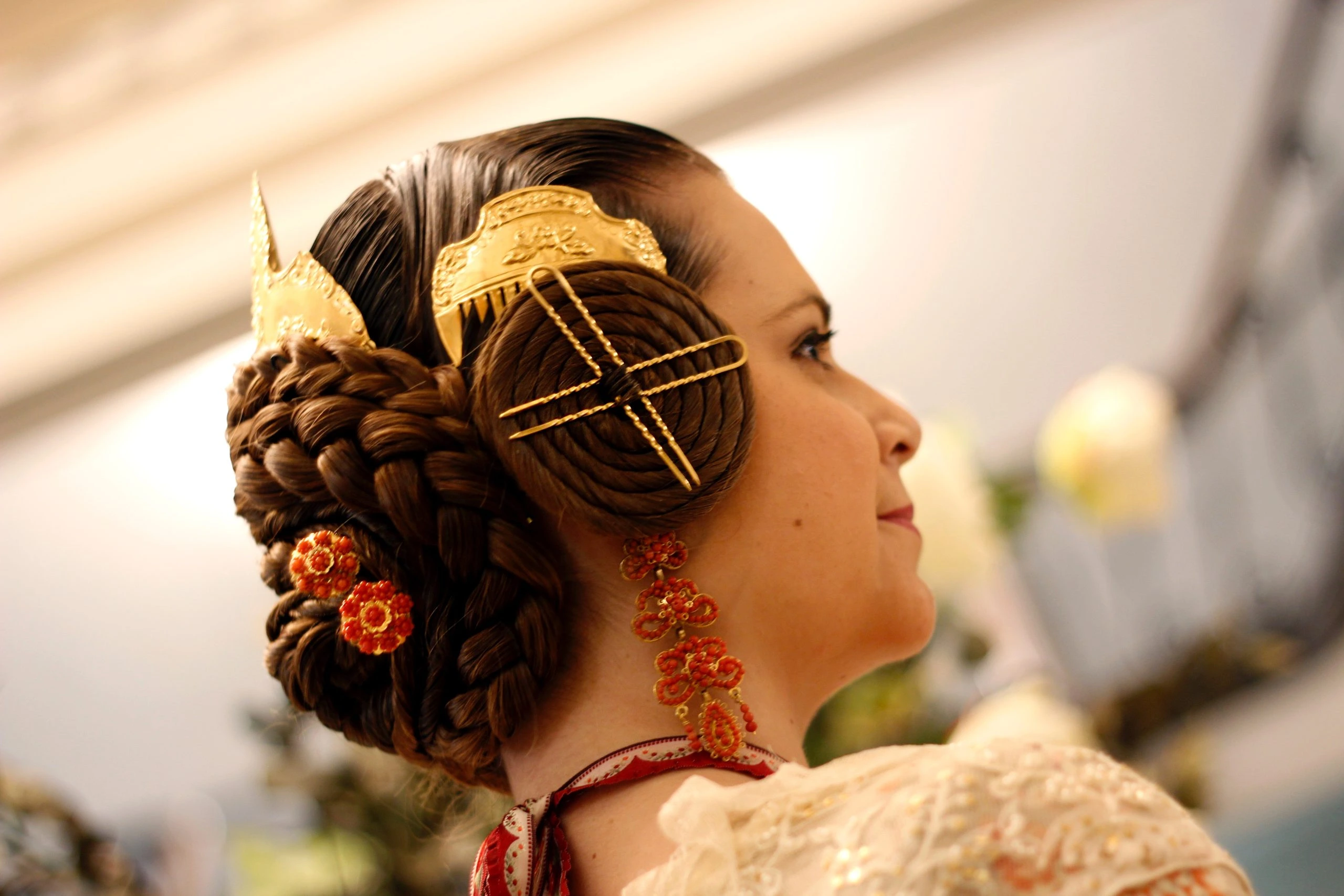 Peinado tradicional de fallera con rodetes y adorno dorado en la moda fallera 2026