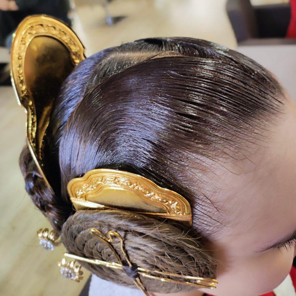 Peinado tradicional fallero con trenzas y complementos dorados