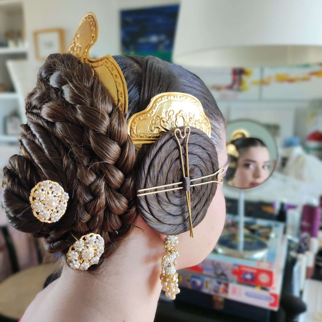 Peinado tradicional de fallera con trenzas laterales y adornos dorados característicos