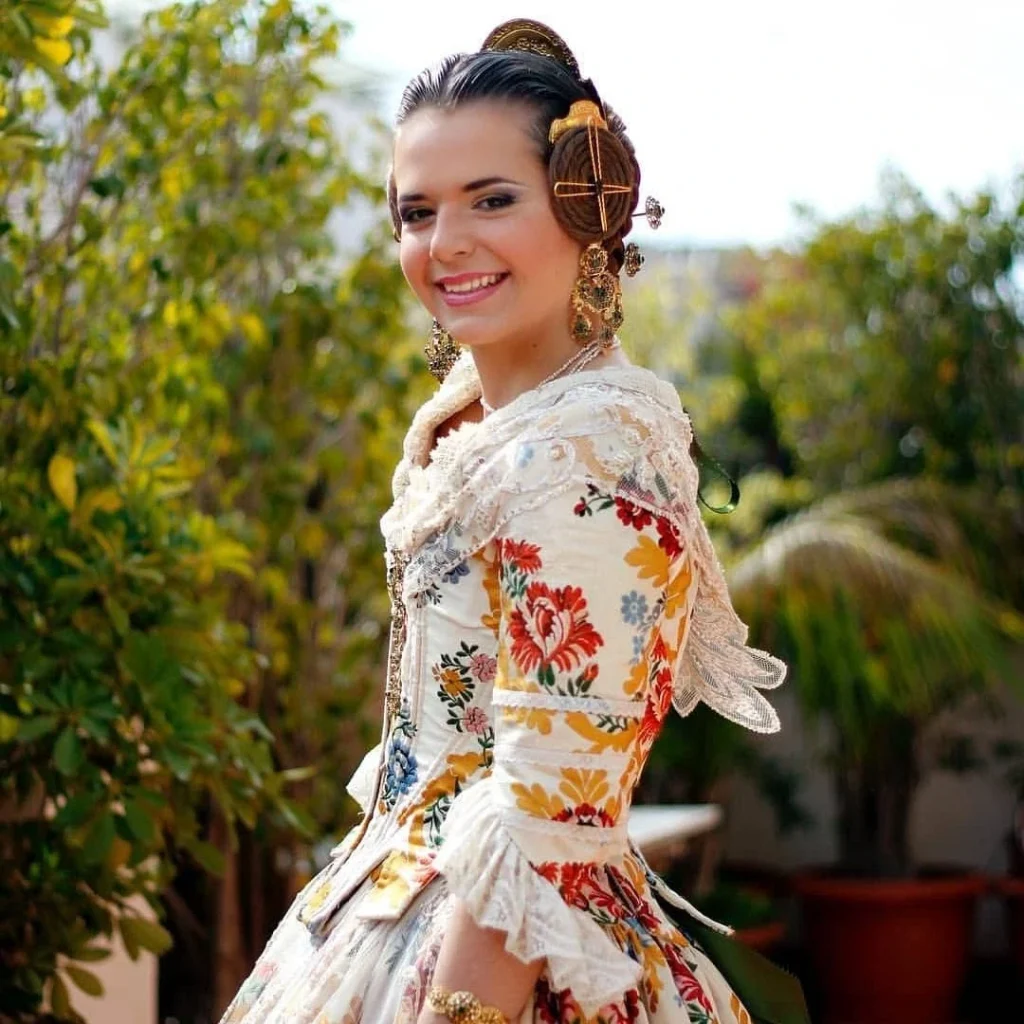 Traje tradicional de fallera con peinado típico y detalles florales