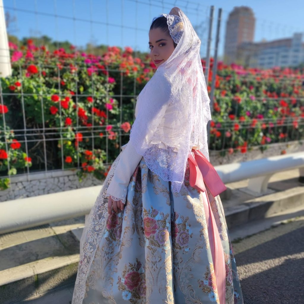 Fallera con traje tradicional valenciano con bordados florales y mantilla de encaje en exterior