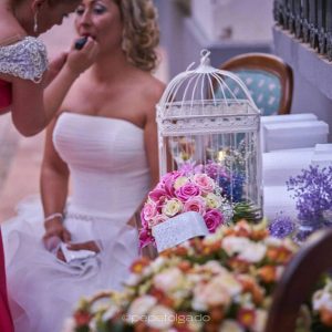 Maquillaje de novia durante la preparación con ramo de flores