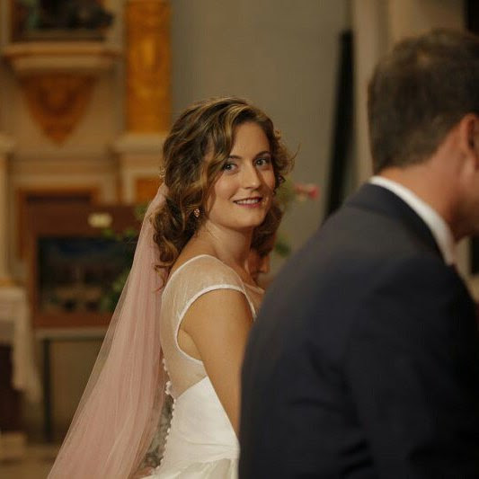 Novia con velo rosa mirando hacia su pareja en la ceremonia
